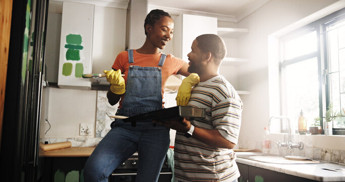 Happy, couple and home improvement with paint in kitchen, talking and plan for renovation and decor. Creative, black woman and man with color for maintenance, smile and DIY makeover in new house - Powered by Adobe