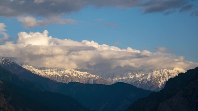 4K timelapse of clouds moving in evening sky over snow covered Himalayan mountains at Kilar, Pangi Valley, India. Evening sunset sky timelapse at mountain during winter. Nature and environment