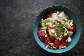 A bowl of colorful fruit salad with a combination of watermelon, strawberries, kiwi, grapes