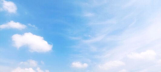 A stunning background of a clear blue sky with delicate white cloud formations on a bright sunny...