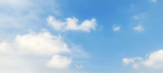 A stunning background of a clear blue sky with delicate white cloud formations on a bright sunny day. Peaceful and serene atmosphere, suitable for themes related to nature, weather, relaxation, travel