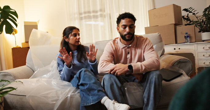 Frustrated, boxes and couple with fight in home for rental eviction, moving out or lease violation. Night, stress and people with argument on sofa for mortgage crisis, financial issue and foreclosure - Powered by Adobe