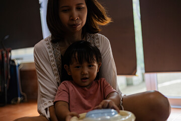 Mother And Toddler Riding A Toy Car In The House