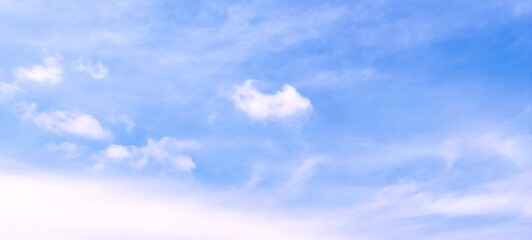 Beautiful scene of soft fluffy white clouds floating in a clear blue sky on a bright summer day, creating a calm and serene atmosphere. Ideal for nature, travel, relaxation, weather themed designs.