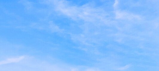 Beautiful scene of soft fluffy white clouds floating in a clear blue sky on a bright summer day,...