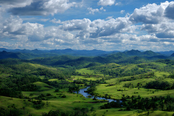 Naklejka premium A Majestic Panoramic Vista with Rolling Hills and Serene River Under a Brilliant Azure Sky