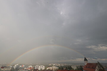A rainbow is seen in the sky above a city