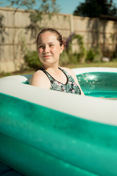 Young teenage girl in inflatable, outdoor swimming pool