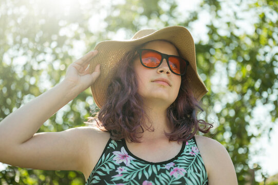 Young girl wearing orange sunglasses and a hat, summer holidays