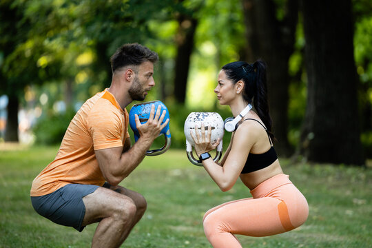 Personal training. Fitness woman exercising kettlebell weightlifting with help of professional trainer. - Powered by Adobe