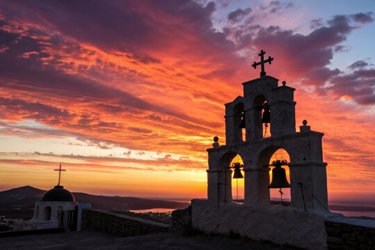 Silhouette of church bell tower with cross against vibrant sunset sky featuring orange red and purple clouds and a second church structure