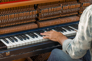piano musical instrument art concept with male hands of unrecognizable person back to camera