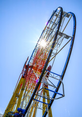 Ferris wheel illuminated at dusk with vibrant colors against a cloudy sky in a festive atmosphere