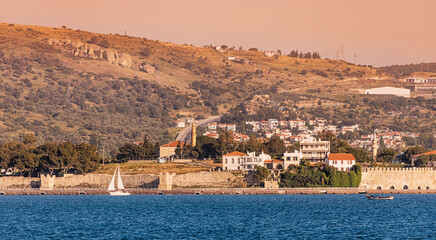 Scenic view of Foca, a charming coastal town in Turkey, with its ancient walls, as a sailboat...