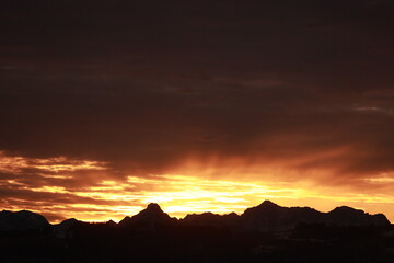 The sun is setting behind a mountain range