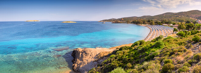 Tranquil bay with crystal clear turquoise water and beach umbrellas inviting to relaxation and...