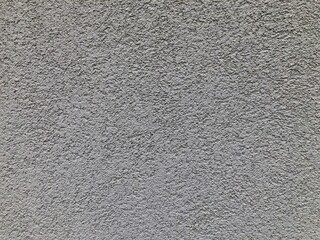 Texture of painted dark gray building facade, close up