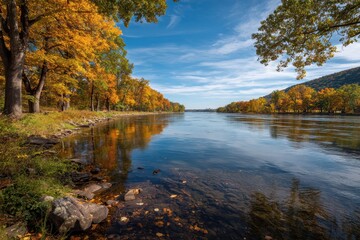 Fototapeta premium Autumn river scene with colorful trees, a flowing river reflecting sky