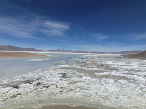 Aerial view of a vast expanse of white salt flats meeting the blue sky, creating a stunning contrast of textures and tones, San Pablo de L&Atilde;&shy;pez, Potosi Department, Bolivia.