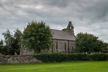 The ancient church of Inniskeen, in County Monaghan, Ireland. It is situated on the banks of the River Fane and was reputedly founded in the 6th century by St. Daig
