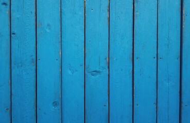 Naklejka premium Blue painted wooden fence with vertical planks. Slight wear on wooden surface. Harmonious blend of colors and textures with beige wall. Symmetrical and balanced scene with old wooden fence.