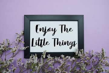 Enjoy The Little Things text with flowers bouquet decoration on purple background