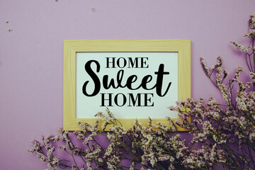 Home Sweet Home text with flowers bouquet decoration on purple background