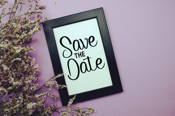 Save The Date text with flowers bouquet decoration on purple background