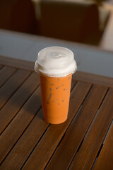 Iced Thai milk tea. Sweet, cold drink. Orange beverage. Refreshing. Asian drink. Topped with milk foam.