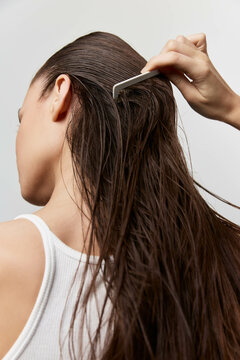 Hair care, grooming, beauty routine, woman combing wet hair, close up shot, natural hair texture, neutral background