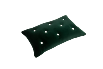 a green pillow with white polka dots on it
