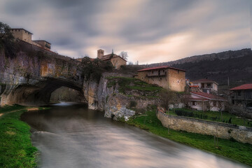 Fototapeta premium Sunset over Puentedey, a picturesque village with a natural bridge over the Nela river. Burgos, Castile and Leon, Spain
