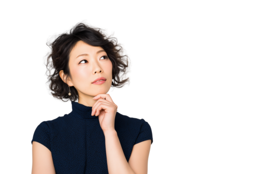 A woman in her thirties with an expression of sadness,  thinking and contemplation, standing against a white background, hands under her chin, deep in thought. She is wearing navy blue