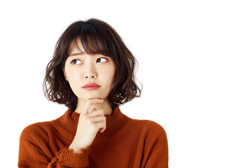 A woman in her thirties with an expression of sadness, thinking and contemplation, standing against a white background, hands under her chin, deep in thought. She is wearing navy blue