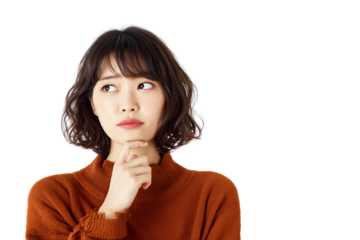 A woman in her thirties with an expression of sadness, thinking and contemplation, standing against a white background, hands under her chin, deep in thought. She is wearing navy blue