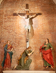 PIACENZA, ITALY - MAY 19, 2025: The carved sculptural group of Crucifixion in the church Basilica...