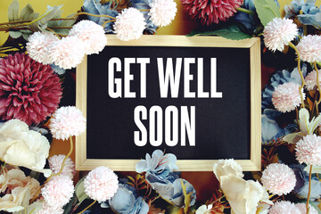 Get Well Soony text with flowers decoration on yellow background
