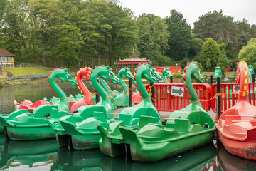 Dragon pedal boats tied up ready for hire on the boating lake in Peasholm Park, Scarborough