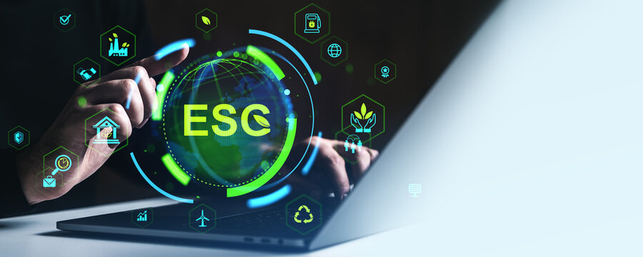 ESG digital interface concept with glowing sustainability and environmental icons around a globe and hands interacting with laptop on dark background.
