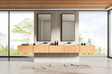 Modern bathroom interior with double sinks, wood cabinetry, large mirrors, and tropical view...
