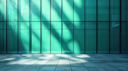 Teal glass wall with sunlight and shadows on floor.