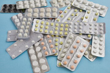 Colorful medicine tablets and capsules in blister packs showing pharmaceutical industry and drug...