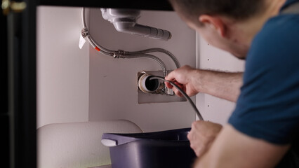 Plumber drill through clogged sink pipes with spring tube tool