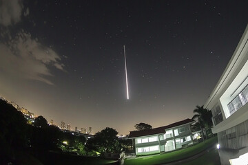 Flaming meteor lights up the night sky over the city