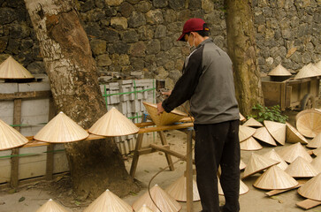 Fototapeta premium Man making the popular headgear of Vietnamese people. Hoa Lu District. Ninh Binh Province. Vietnam.