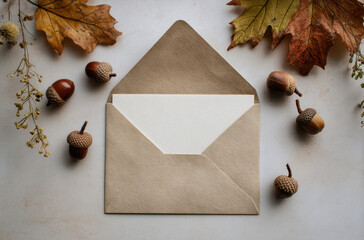 An envelope surrounded by acorns and autumn leaves. October 9 - World Postal Day