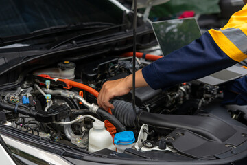 Mechanic inspects car engine with precision and care