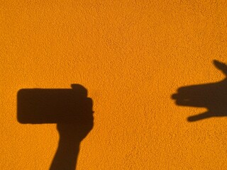 Shadow Play on Golden Wall: Smartphone Hand and Second Hand Silhouettes for Digital Interaction,...