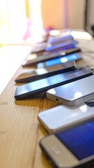 Row of smartphones on a wooden table
