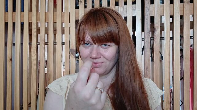 Redhead woman pointing with her finger like hey you, come here